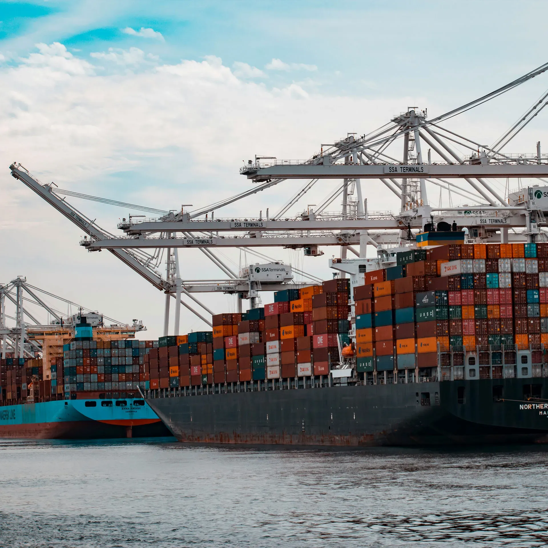 Container ship being loaded by gantry cranes at a port